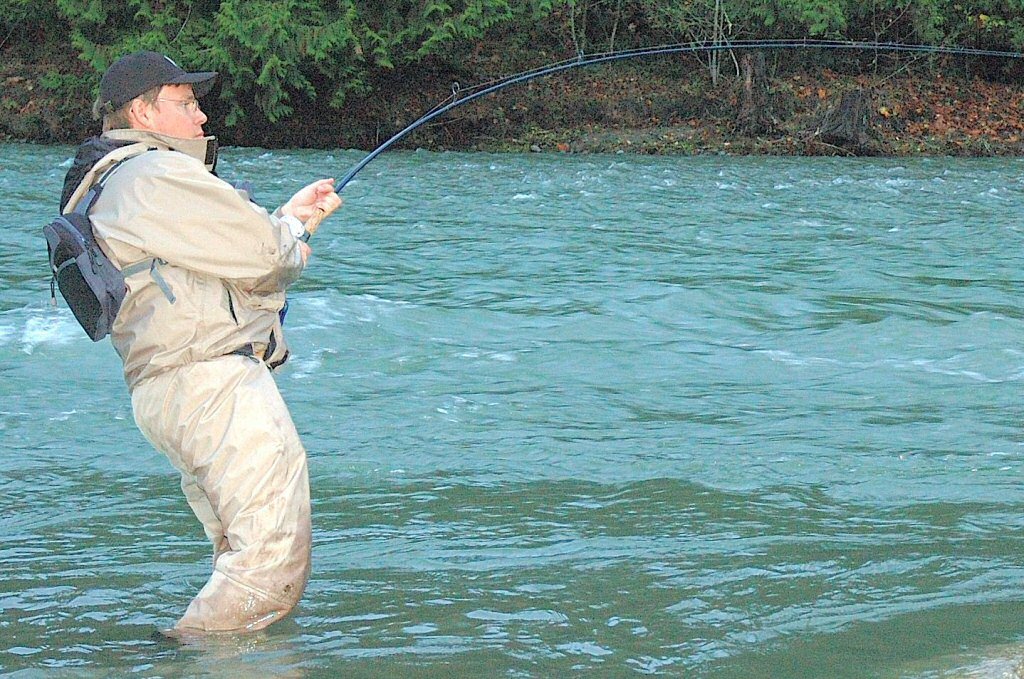Ole kæmper med en stor laks nedstrøms