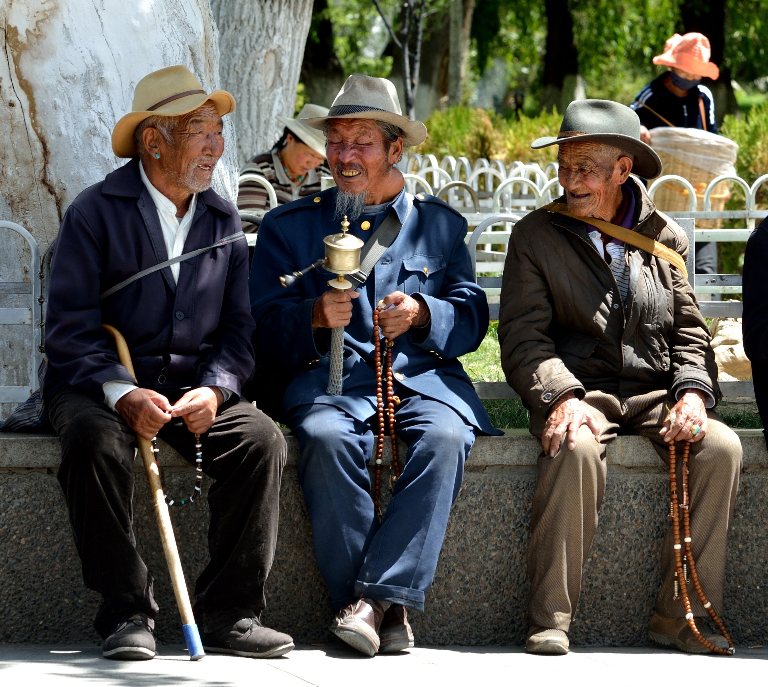 Karin med glade gamle tibetanske mænd i parken bag Potala