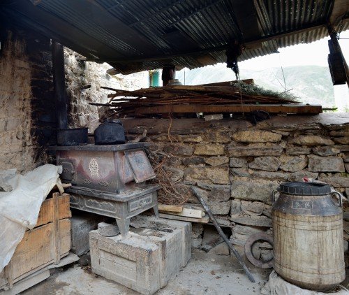 Gammelt træfyret komfur i gården — som om tiden er gået i stå